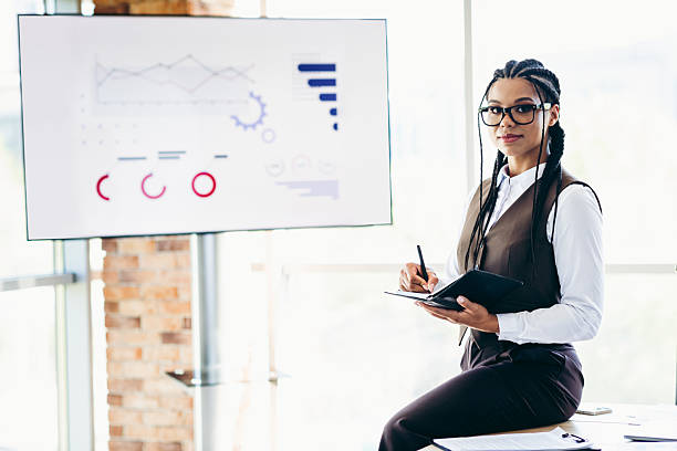 istock Confident businesswoman holding notebook and pen in modern office during presentation analysis 2225376671