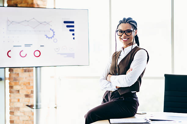 istock Professional young professional businesswoman presenting data analytics in a modern office environment with charts on display 2225377223