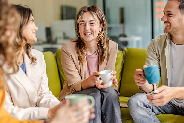 istock Team members engage in collaborative discussion over coffee in a modern office setting 2225377467
