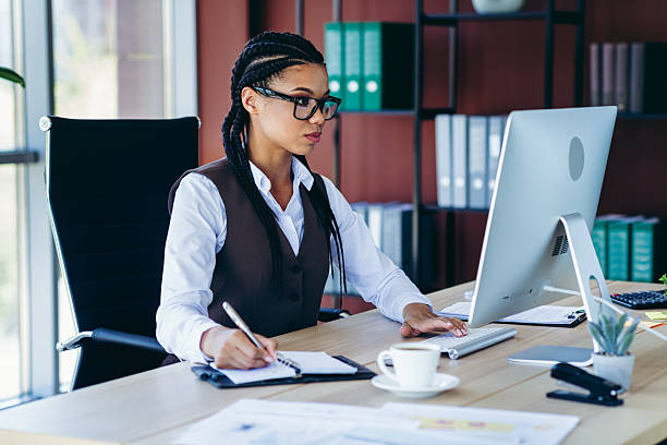 istock Professional businesswoman working with determination in a modern office setting surrounded by computers and documents 2225377712