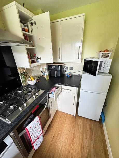 istock Image of small kitchen interior, white glossy cupboards, modern cabinets, integrated fridge freezer, microwave oven, gas hob appliances 2225380472