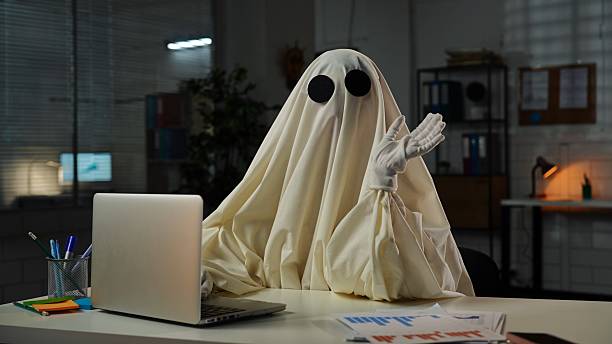 istock Humorous Office Scene with Ghost Costume at Desk 2225384148