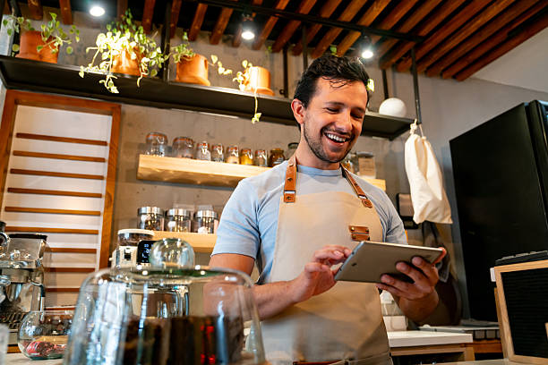 istock Happy barista working at a coffee shop using a digital tablet 2225385002