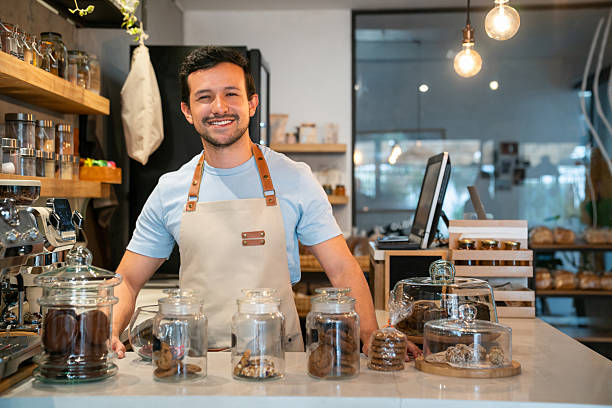 istock Happy waiter working at a pastry shop and smiling 2225385010