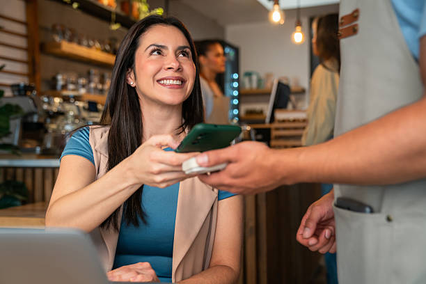 istock Woman making a mobile payment at a coffee shop 2225385023