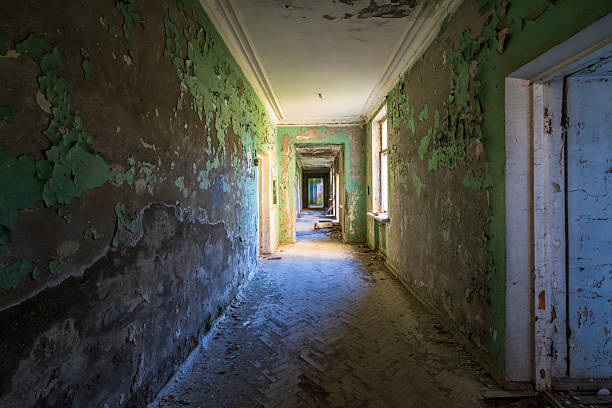 istock Abandoned hallway with peeling paint, broken floor, eerie light. Post-apocalyptic, horror, mystery and historical architecture concept 2225385797