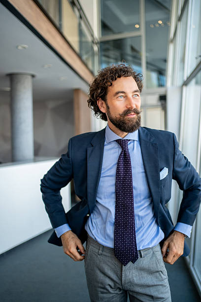 istock Confident businessman looking up in modern office 2225387492