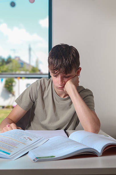 istock Teenage boy doing home work 2225389789