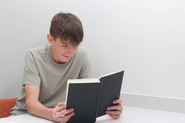 Close-up view of a boy’s hands holding a rosary over an open Bible, symbolizing prayer, faith, and spiritual devotion.