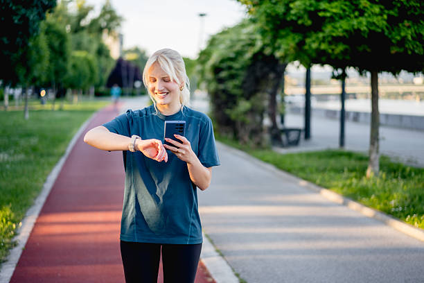 istock Young woman checking smartwatch on running track 2225401168