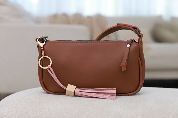 istock Stylish bag with pink leather keychain on soft surface indoors 2225401486