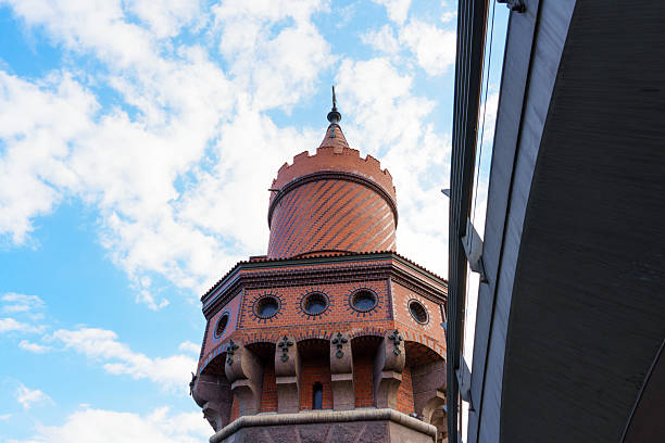 An iconic historic water tower in Berlin, Germany, surrounded by lush green trees and a beautiful sky, capturing the essence of architectural heritage.Wasserturm, Berlin, Prenzlauer Berg