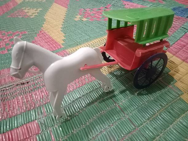 mother and sons are enjoying in the backyard, mother is pushing a children's toy truck with a son.
