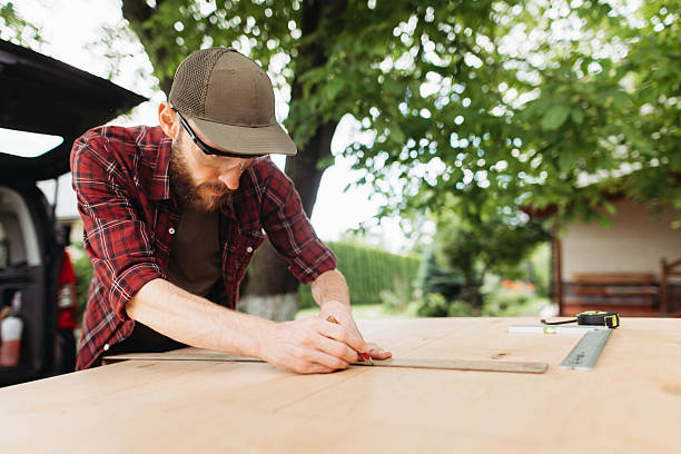 istock Carpenter Measuring Wood in an Outdoor Workspace with Greenery 2225408054