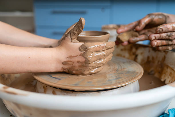 istock Hands shaping clay cup on pottery wheel, teamwork concept 2225408184