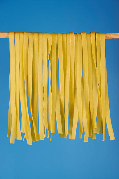 istock Egg fettuccine, fresh pasta drying on a wooden stick 2225408531