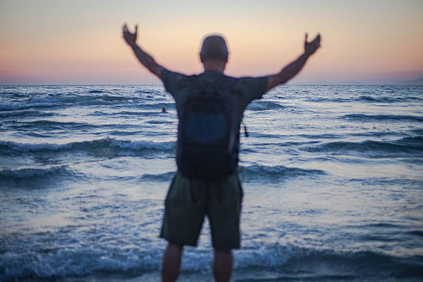 A man enjoys watching the sunset on the sea horizon