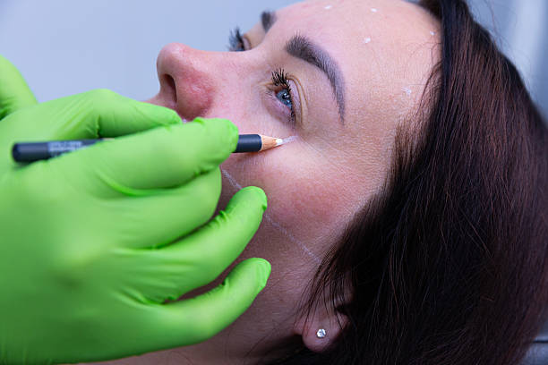 istock Aesthetic Procedure in Progress: Precise Marking for Cosmetic Enhancement Using Professional Techniques and Equipment by a Skilled Technician with Protective Gear 2225410317