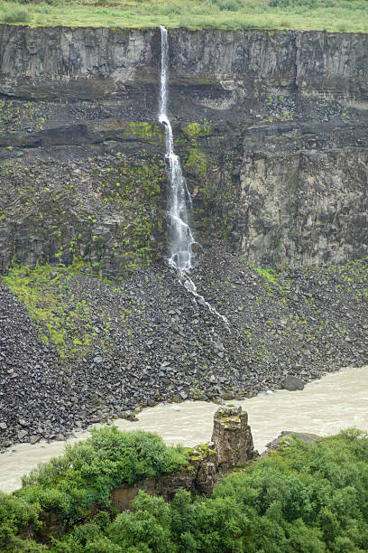 istock Waterfall cascading down a cliff into a river in iceland 2225412020