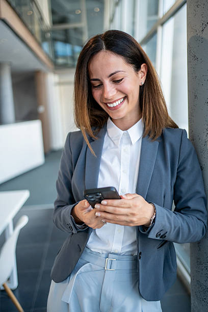 istock Smiling businesswoman using smartphone in modern office 2225413061