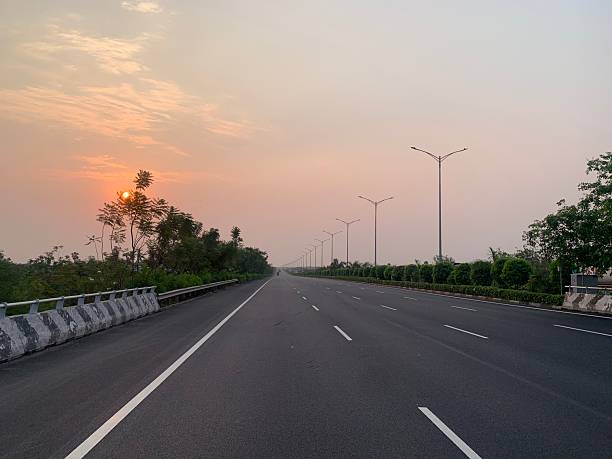 istock Empty Asphalt Road with Street Lights and Greenery in Urban Setting 2225414362