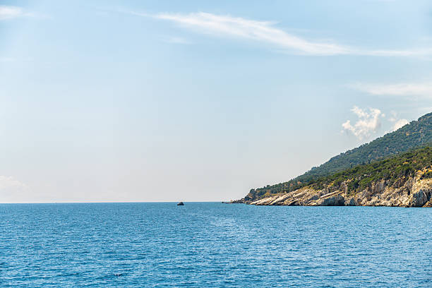 Icarus or Ikarus rock mythological landmark on coast of Ikaria, Greece longevity blue zone Aegean island, view from ferry on Icarian sea