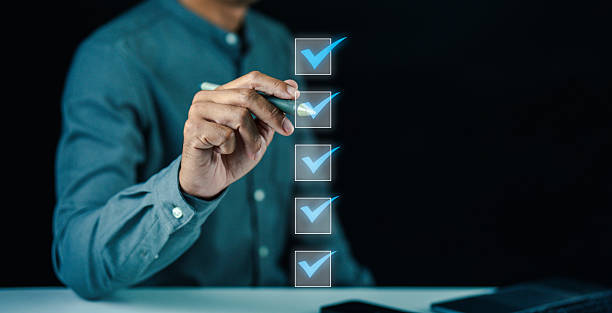 istock A person in a blue shirt marks checkboxes on a transparent digital interface, symbolizing task completion or decision-making. 2225414769