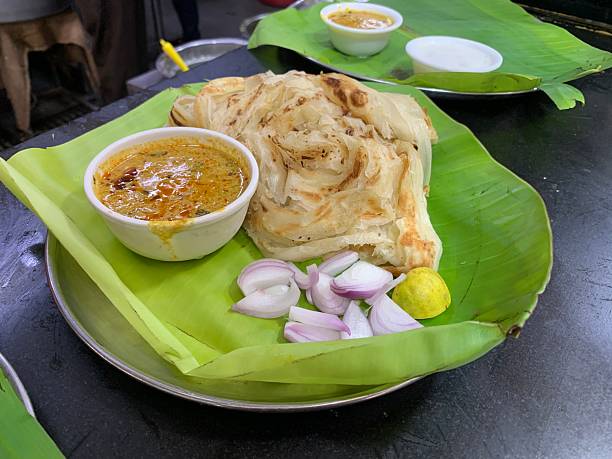 istock Traditional South Indian Parotta with Curry on Banana Leaf Plate 2225417403