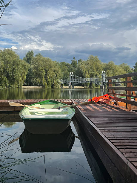 istock Peaceful Dock by the Lake with a Green Rowboat 2225417901