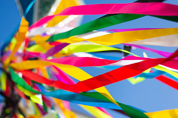 Colorful plastic ribbons flying outdoors against a blue sky. Decorative pieces. Culture.