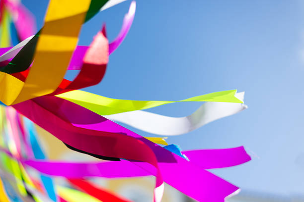 Colorful plastic ribbons flying outdoors against a blue sky. Decorative pieces. Culture.