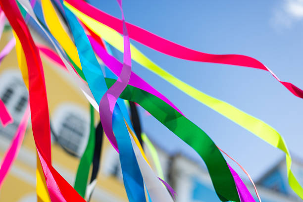 Colorful plastic ribbons flying outdoors against a blue sky. Decorative pieces. Culture.