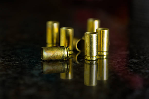 istock Cartridge cases ejected from a 9mm semi-automatic pistol, with reflection on granite 2225422511