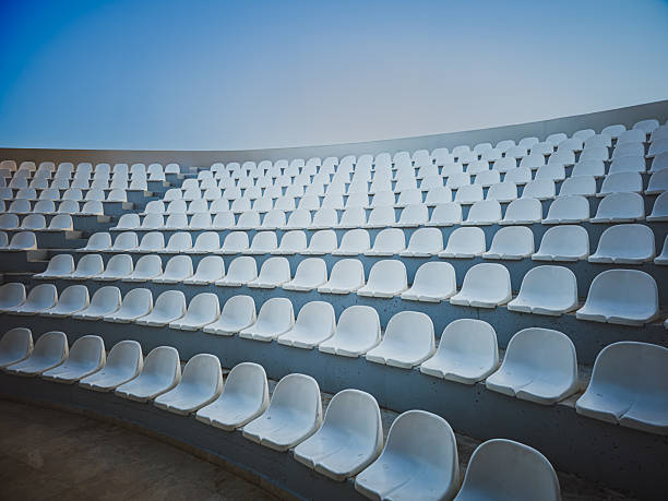 Looking down on the curved arc of rows of concrete bench seating and steps in an old sports stadium - Boston Massachusetts