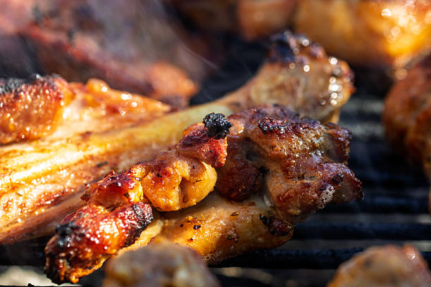 istock Pork chops, steak, sausages on barbecue grill with smoke 2225424020