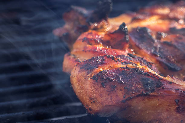istock Pork chops, steak, sausages on barbecue grill with smoke 2225424304