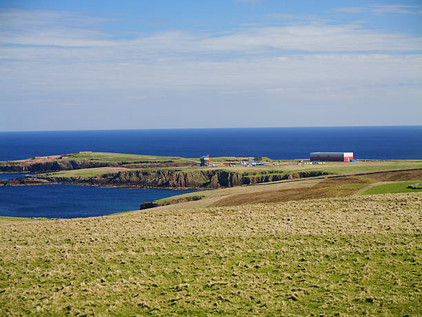 Shetland, UK - Jun 07 2025: A  long shot of Saxavord Space Port nestled on the rugged coastline of Unst, Shetland, under a vast blue sky.