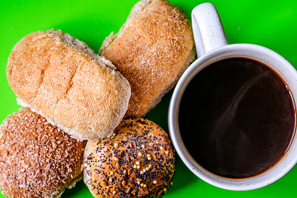 London UK, July 15 2025, Selection Or Group Of Baked Mixed Mini Bread Rolls With A Mug Of Black Coffee Beverage
