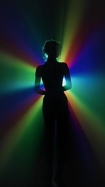 istock Silhouette of woman in rainbow light burst 2225428510