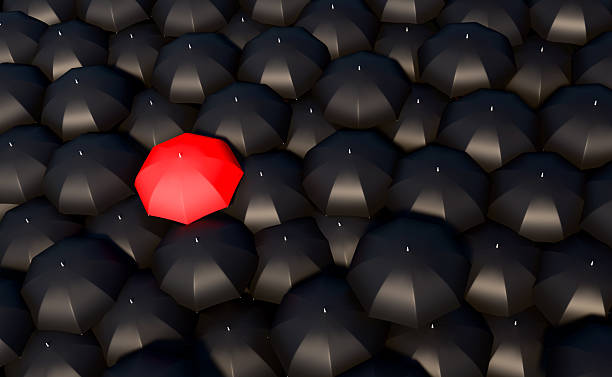 istock Black umbrellas and one is red. 2225429103