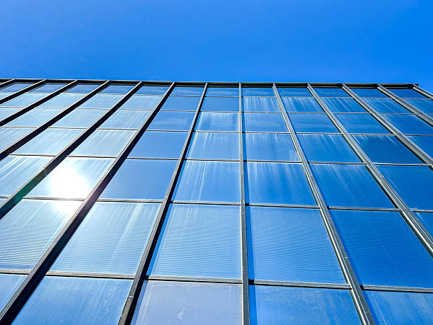 istock Modern glass building reflecting blue sky during a clear day 2225430412