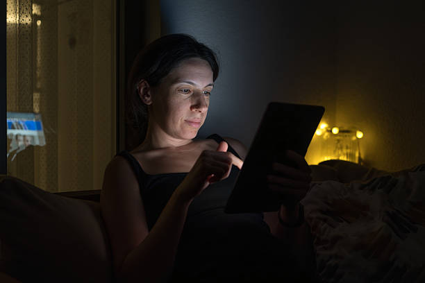 istock Woman Using Tablet at Night on Cozy Balcony Sofa 2225434852