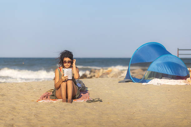 istock Young woman and tent on the beach 2225436821