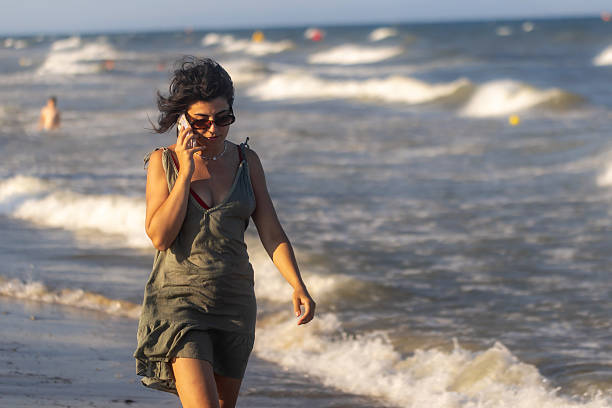 istock Woman with Mobile on Beach 2225441068