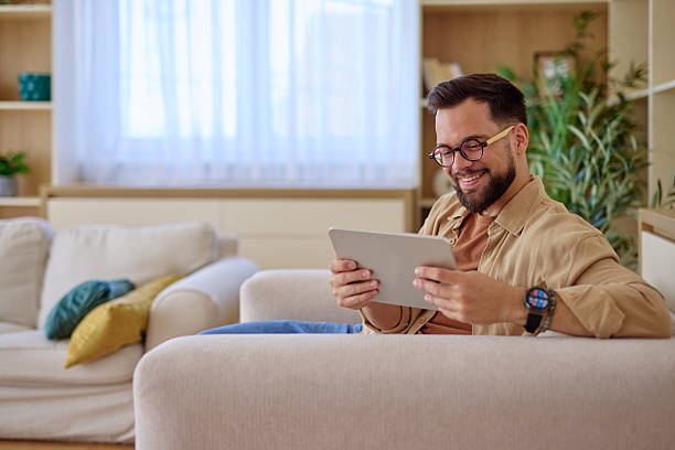 istock Young man relaxing on the sofa using a digital tablet at home 2225445457
