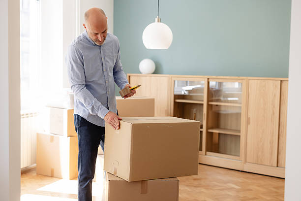 istock A man is preparing a cardboard box in a bright modern room during the moving process 2225447826