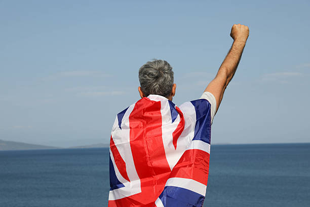 istock Senior Man With UK Flag On Coastal View 2225449711