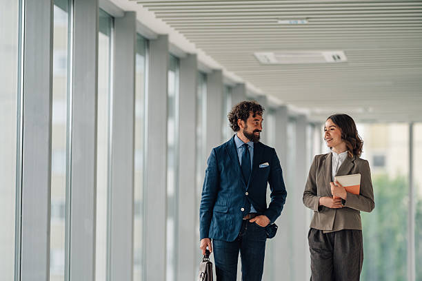 istock Businesspeople walking and talking in modern office corridor 2225451540