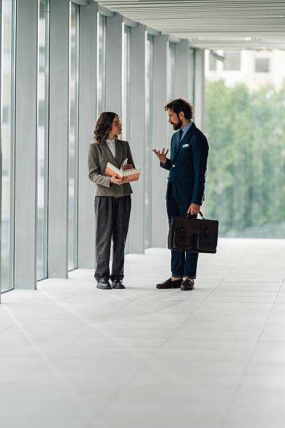 istock Businesspeople discussing work in modern office corridor 2225451592