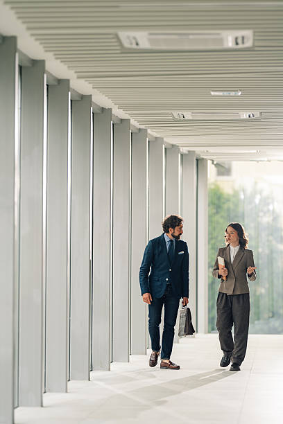 istock Businesspeople walking and talking in modern office corridor 2225451606